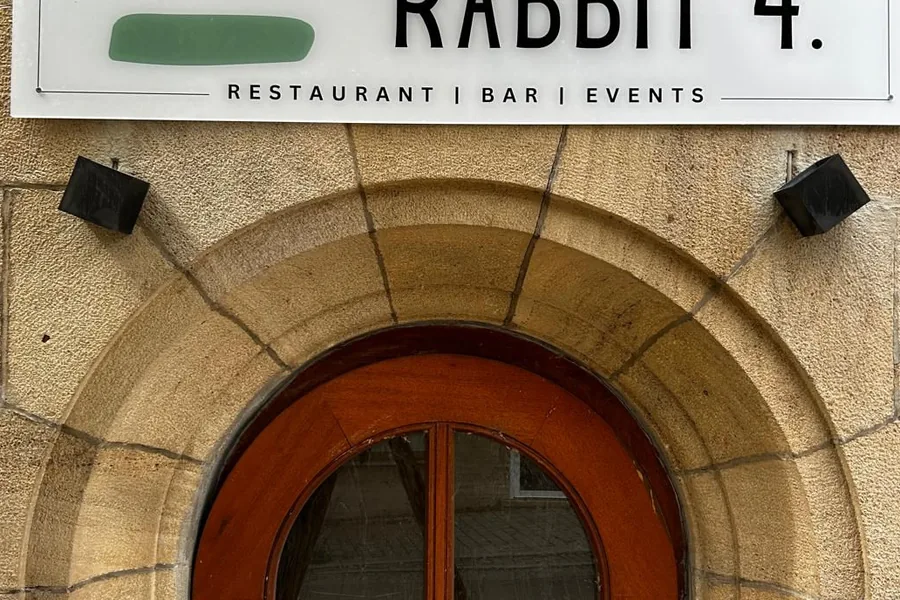 Steinerner Rundbogen über der Eingangstür des Rabbit 4 mit dem weißen Schild darüber