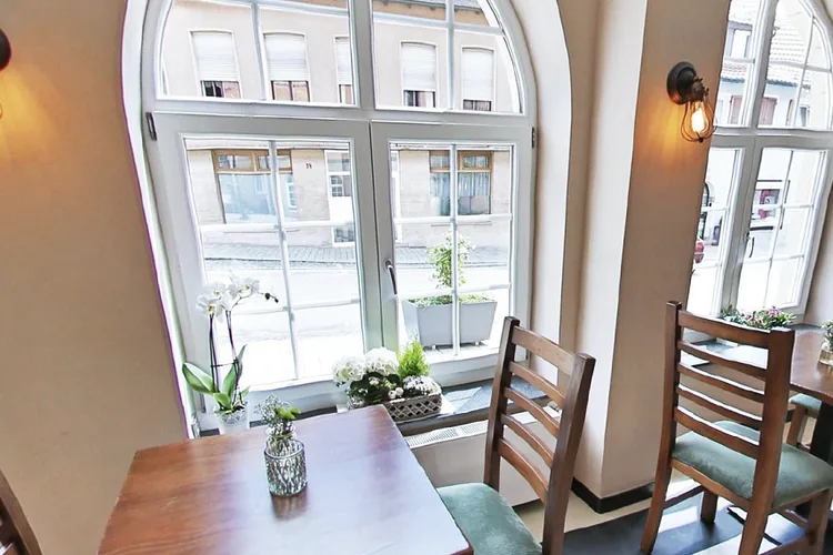 Gedeckte Tische im Restaurant des Rabbit 4 vor den hohen Rundbogenfenstern zur Hauptstraße